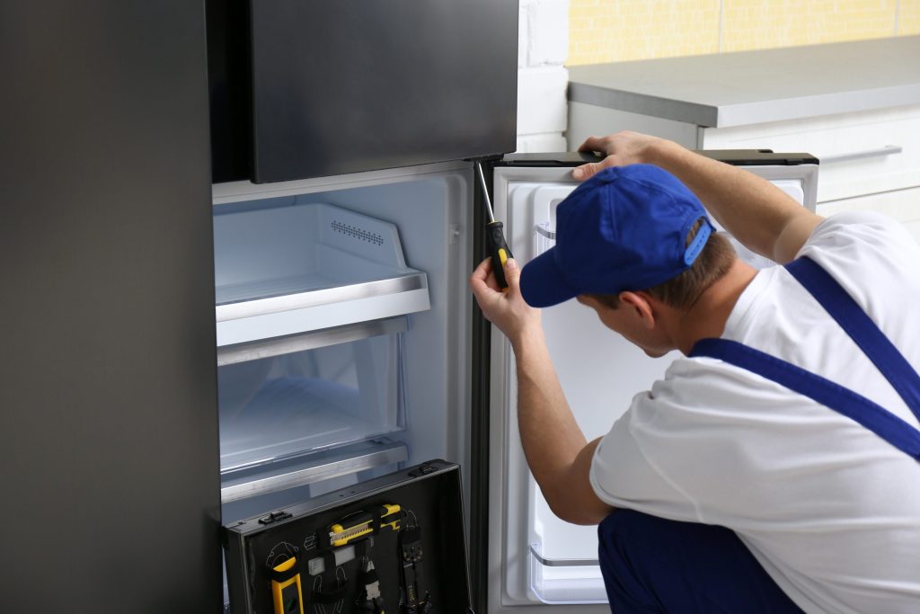 Emergency repair technician inspecting freezer not freezing in Dainfern