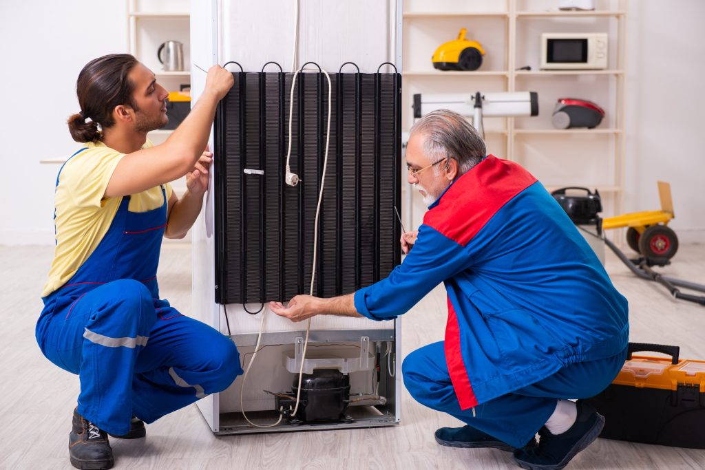 Service technician repairing a home appliance with professional tools. Represents Appliance Man appliance repair services including refrigerators, freezers, dishwashers, washing machines, dryers, microwaves, ovens, stoves, and cooktops.